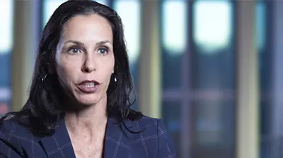 Headshot of a woman looking forward, she is wearing business clothes