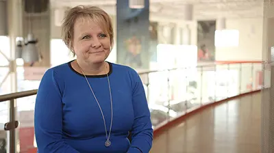 A woman in a blue dress sitting for an interview